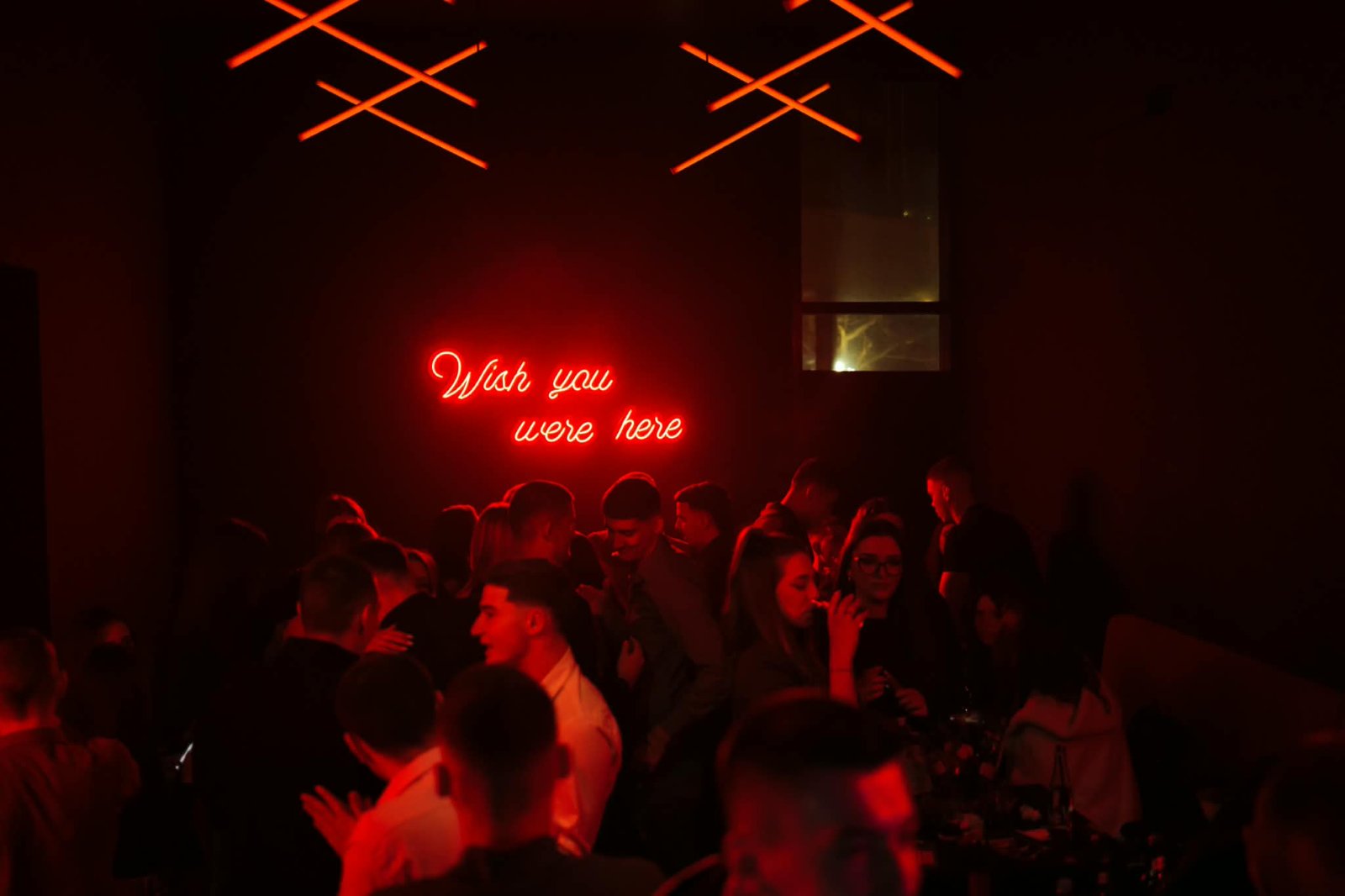 Mood Bar Mostar — neonski znak 'Wish you were here' iznad plesnog podija